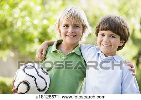 Two young boys outdoors with soccer ball smiling View Large Photo Image Stock Image - Two young boys outdoors with soccer ball smiling. Fotosearch