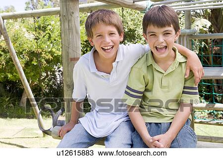 Two young male friends at a playground smiling View Large Photo Image Stock Image - Two young male friends at a playground smiling. Fotosearch