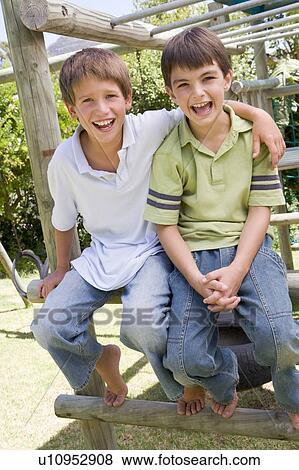 Two young male friends at a playground smiling View Large Photo Image Stock Photo - Two young male friends at a playground smiling. Fotosearch