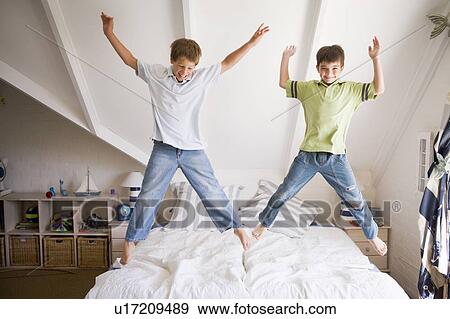 Stock Photo - Young Girl Jumping On Her Bed. Fotosearch