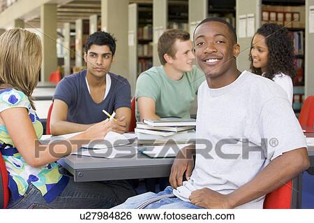 Stock Photograph - Five people in library studying (selective focus). Fotosearch