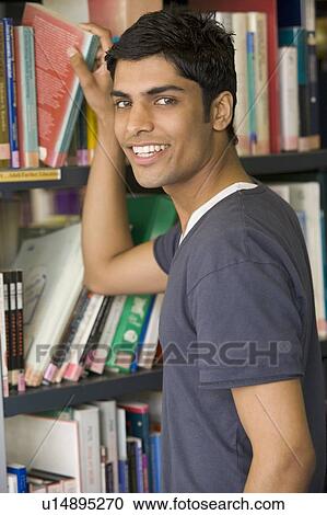 Man in library pulling book off shelf View Large Photo Image Stock Image - Man in library pulling book off shelf. Fotosearch