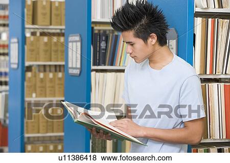 Man in library reading book (depth of field) View Large Photo Image Stock Photo - Man in library reading book (depth of field). Fotosearch