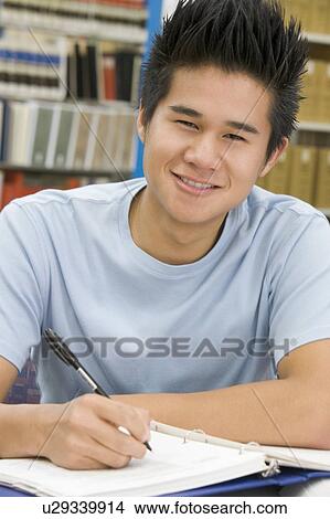 Picture - Man sitting in library studying. Fotosearch