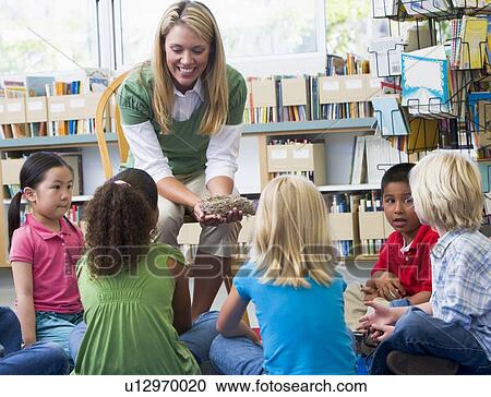 Stock Image - Teacher in class showing students a nest. Fotosearch