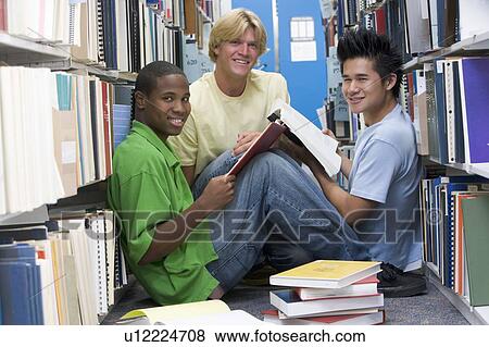 Stock Photo - Three men sitting on floor in library with books. Fotosearch