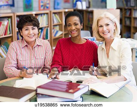 Three women sitting in library with books and notepads (selective focus) View Large Photo Image Stock Photography - Three women sitting in library with books and notepads (selective focus). Fotosearch