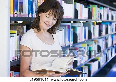 Woman in library reading book (depth of field) View Large Photo Image Stock Image - Woman in library reading book (depth of field). Fotosearch