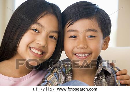 Brother And Sister Sitting On Their Sofa At Home View Large Photo Image Stock Photo - Brother And Sister Sitting On Their Sofa At Home. Fotosearch