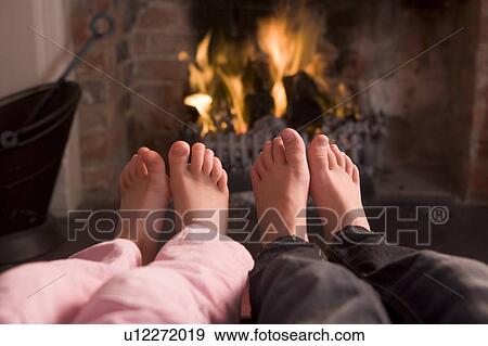Couple's feet warming at a fireplace View Large Photo Image Stock Photo - Couple's feet warming at a fireplace. Fotosearch
