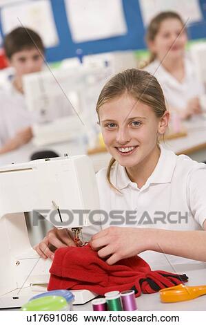 Stock Photograph - Female student using sewing machine. Fotosearch