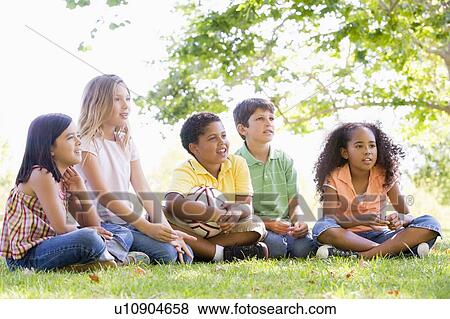 Five young friends sitting outdoors with soccer ball View Large Photo Image Stock Photo - Five young friends sitting outdoors with soccer ball. Fotosearch
