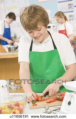 Male student slicing berries in cooking class View Large Photo Image Stock Image - Male student slicing berries in cooking class. Fotosearch