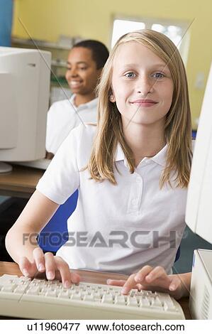 Student at computer terminal typing with student in background (selective focus) View Large Photo Image Stock Photo - Student at computer terminal typing with student in background (selective focus). Fotosearch