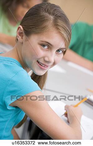 Stock Image - Student in class taking notes (selective focus). Fotosearch