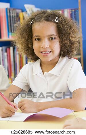 Stock Photography - Student in class writing in notebook (selective focus). Fotosearch