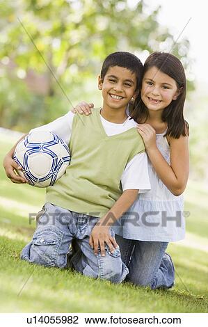 Two young children outdoors in park with ball smiling (selective focus) View Large Photo Image Stock Image - Two young children outdoors in park with ball smiling (selective focus). Fotosearch