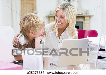 Woman and young boy in home office with laptop smiling View Large Photo Image Stock Photography - Woman and young boy in home office with laptop smiling. Fotosearch