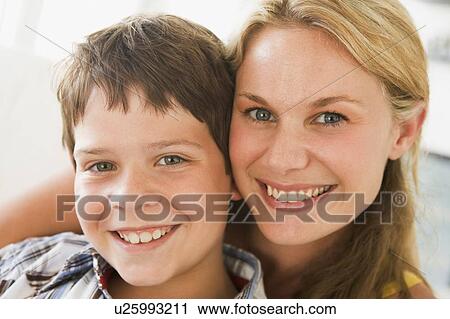 Stock Image - Woman and young boy in living room smiling. Fotosearch