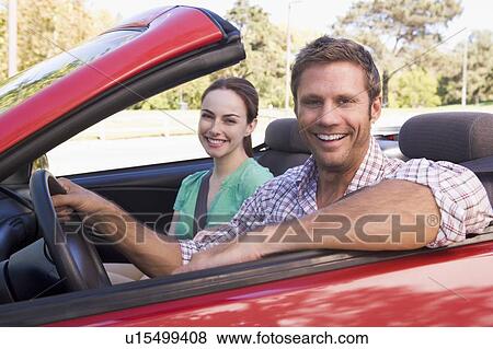 Stock Photo - Couple in convertible car smiling. Fotosearch