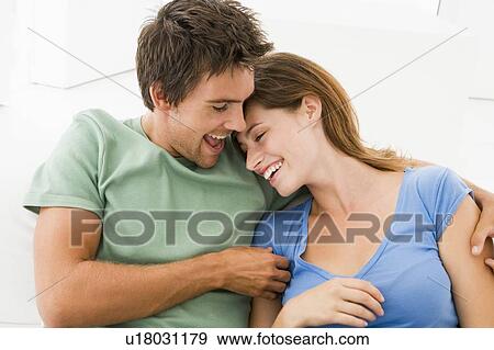 Stock Photo - Couple in living room smiling. Fotosearch