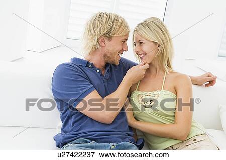Stock Photo - Couple in living room smiling. Fotosearch