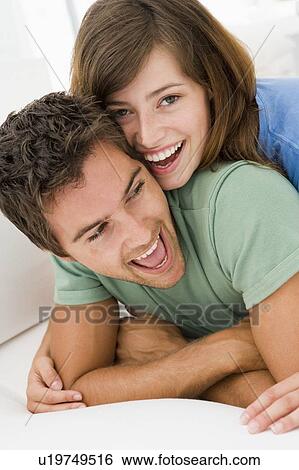 Stock Photograph - Couple in living room smiling. Fotosearch