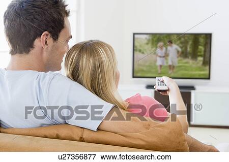 Stock Photo - Couple in living room watching television. Fotosearch
