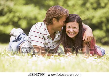 Couple lying outdoors smiling View Large Photo Image Stock Image - Couple lying outdoors smiling. Fotosearch
