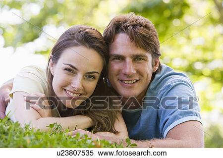 Couple lying outdoors smiling View Large Photo Image Stock Photography - Couple lying outdoors smiling. Fotosearch