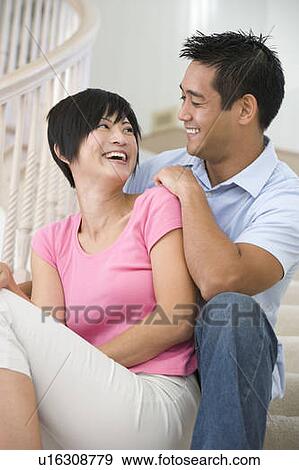 Stock Photo - Couple sitting on staircase smiling. Fotosearch