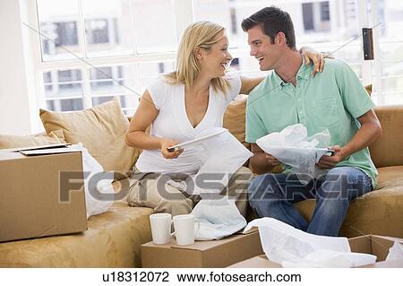 Couple unpacking boxes in new home smiling View Large Photo Image Stock Image - Couple unpacking boxes in new home smiling. Fotosearch
