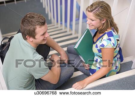 Two students sitting on staircase with notebooks (selective focus) View Large Photo Image Stock Photo - Two students sitting on staircase with notebooks (selective focus). Fotosearch