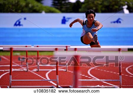 Female athlete jumping hurdles, front view View Large Photo Image Stock Image - Female athlete jumping hurdles, front view. Fotosearch
