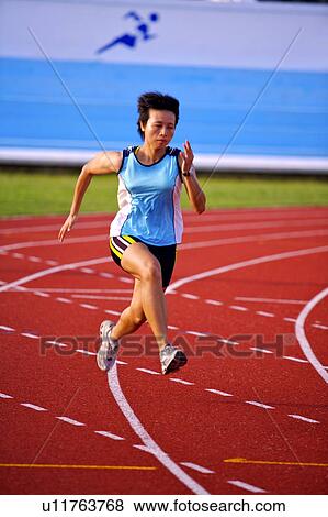 Stock Photo - Female athlete running on race track. Fotosearch