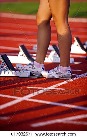 Female athlete standing beside the track starting block View Large Photo Image Stock Image - Female athlete standing beside the track starting block. Fotosearch