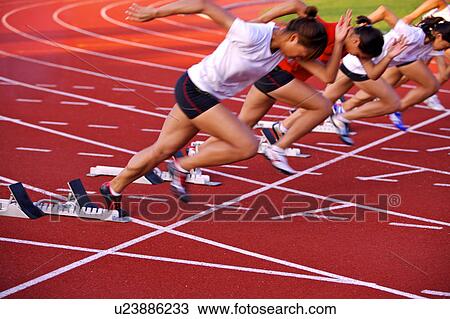 Stock Image - Female athletes running on race track. Fotosearch