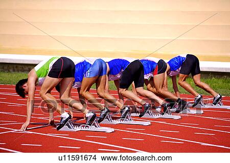 Picture - Five male athletes on the track starting block. Fotosearch