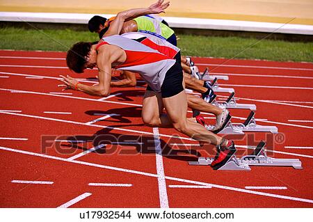 Picture - Five male athletes running from track starting blocks. Fotosearch