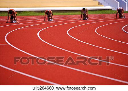 Stock Image - Four male athletes getting ready to run. Fotosearch