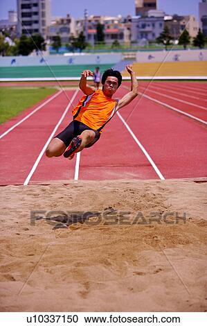 Male athlete long jumping, mid-air View Large Photo Image Stock Image - Male athlete long jumping, mid-air. Fotosearch