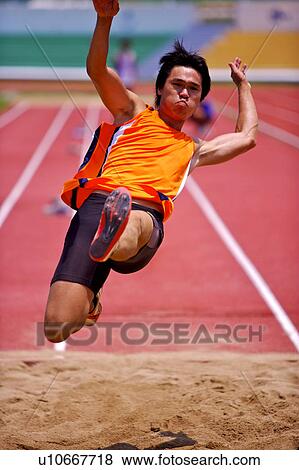 Male athlete long jumping, mid-air View Large Photo Image Stock Photo - Male athlete long jumping, mid-air. Fotosearch