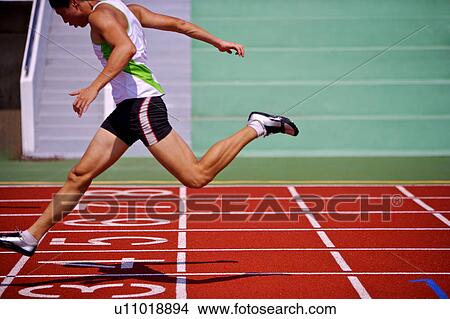 Picture - Male athlete running across the finish line. Fotosearch