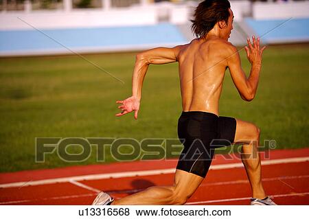 Male athlete running on race track View Large Photo Image Stock Photo - Male athlete running on race track. Fotosearch