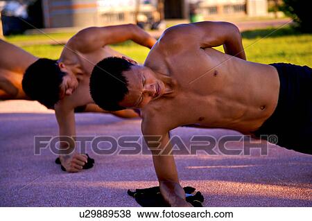 Stock Photo - Male athletes doing push-ups. Fotosearch