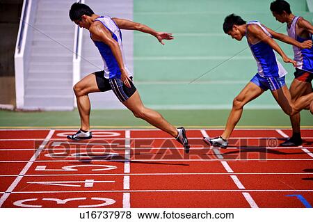 Stock Photo - Three male athletes running to the finish line. Fotosearch