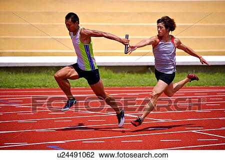 Two male athletes passing relay baton View Large Photo Image Stock Image - Two male athletes passing relay baton. Fotosearch
