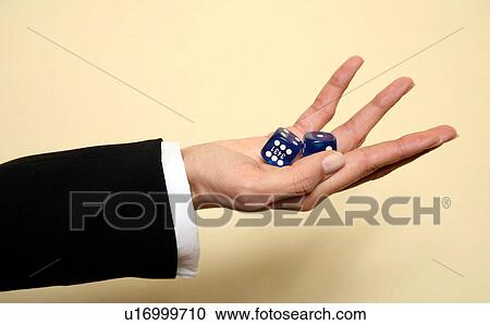 Stock Image - A woman holding a pair of blue dice . Fotosearch