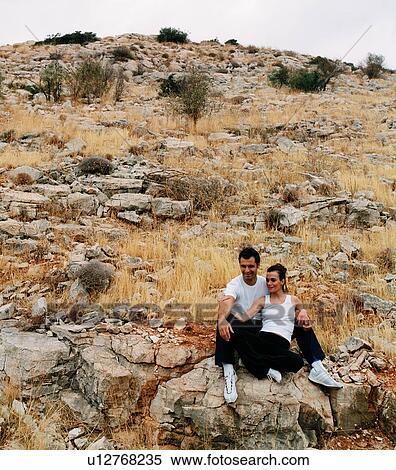Athletic couple sitting on rock View Large Photo Image Stock Photography - Athletic couple sitting on rock. Fotosearch