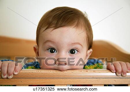 Baby chewing on crib View Large Photo Image Stock Photography - Baby chewing on crib. Fotosearch